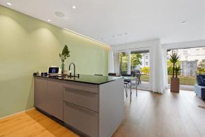 eine Küche mit grünen Wänden und einer Kücheninsel in der Unterkunft The R Apartment Uetliberg Parken - Wallbox in Geroldswil + 23 Fotos