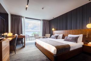 ein Hotelzimmer mit einem großen Bett und einem Schreibtisch in der Unterkunft Golan Hotel in Tiberias