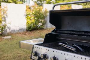 a grill with two tongs on top of it at The R Apartment Uetliberg, Klima, Parken - Wallbox in Geroldswil