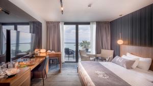 ein Hotelzimmer mit einem großen Bett, einem Schreibtisch und einem Esszimmer in der Unterkunft Golan Hotel in Tiberias