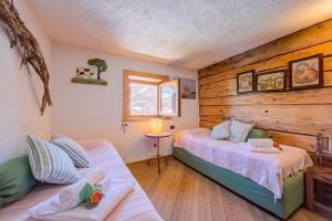 a bedroom with two beds and a couch at Chalet Lidia Ski in-Ski out 50m - Happy Rentals in Livigno
