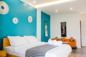 a bedroom with a blue wall and a bed at Holabay Resort in Panglao Island