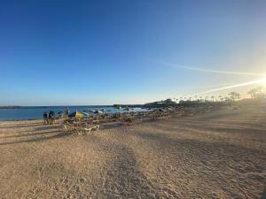 een strand met stoelen en parasols op het zand bij Apartment With Jacuzzi and pool access in Puerto Rico de Gran Canaria