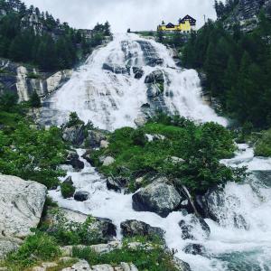 una cascata sul fianco di una montagna di Sentiero Verde B&B a Formazza