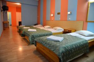 a group of four beds in a room at Hotel Korinthos in Korinthos