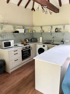 a kitchen with white cabinets and a white counter top at Blairbeg Cottage in Blairgowrie