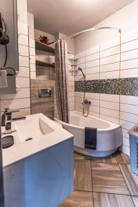 uma casa de banho branca com uma banheira e um lavatório em Olivia apartament przy deptaku em Szczawno-Zdrój