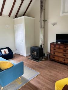 un soggiorno con divano blu e piano cottura di Blairbeg Cottage a Blairgowrie