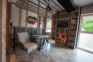a room with a chair and a table and a book shelf at Olivia apartament przy deptaku in Szczawno-Zdrój