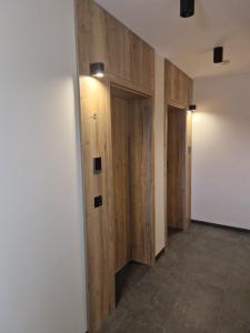 a hallway with wooden doors in a room at Zatoka Wypoczynku Apartamenty in Władysławowo