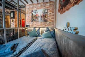 uma cama num quarto com uma parede de tijolos em Olivia apartament przy deptaku em Szczawno-Zdrój