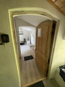 - un couloir avec une porte en bois menant au salon dans l'établissement Appartement cosy plein de charme, à Saint-Rémy-de-Provence