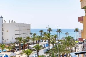 a view of a beach with palm trees and the ocean at Elegante Apartamento cerca al mar in Roquetas de Mar