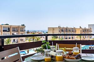 una mesa con un plato de comida en el balcón en Elegante Apartamento cerca al mar en Roquetas de Mar