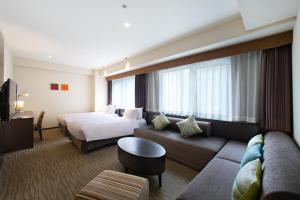 ein Hotelzimmer mit einem Bett und einer Couch in der Unterkunft Holiday Inn Osaka Namba by IHG in Osaka
