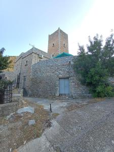 a stone building with a clock tower on top of it at pyrgospito in Éxo Nímfion