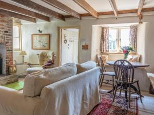 ein Wohnzimmer mit einem Sofa und einem Tisch in der Unterkunft End Cottage in Kingsbridge