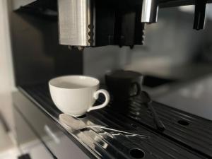 una tazza di caffè e cucchiai su un bancone in un forno a microonde di LULEX V - Villa Ländlich Zentral Messe Flughafen a Krefeld Altre 16 foto