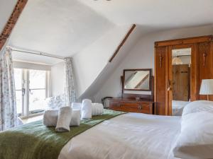 ein Schlafzimmer mit einem großen Bett und einem Spiegel in der Unterkunft End Cottage in Kingsbridge