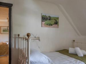 a bedroom with a bed and a picture on the wall at Rose Thatch in Kingsbridge
