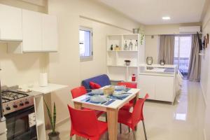 a kitchen with a table and red chairs in a room at Apart26 C425 Dpto hermoso en Tucumán in San Miguel de Tucumán