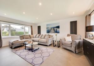 a living room with a couch and chairs and a table at Mor a Mynydd in Abersoch