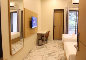 a hotel room with two beds and a mirror at Ixoras Hotel Lemba in Kinshasa
