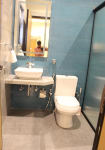 a bathroom with a toilet and a sink and a mirror at Ixoras Hotel Lemba in Kinshasa