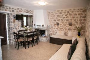 a living room with a dining table and a stone wall at Anna's Garden in Triandafilliá