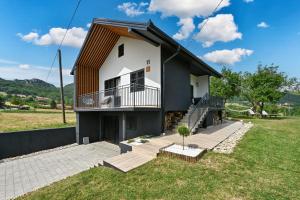 ein Haus mit einem Balkon und einem Hof in der Unterkunft Vacation Home - NEST Kalnik in Kalnik