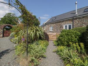 un giardino di fronte a una casa in pietra di No 1 The Granary a Llangefni