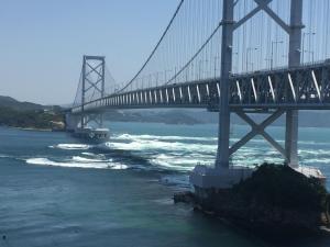 鳴門市にあるオーベルジュ鳴門の波立つ川にかかる橋 +11枚の写真