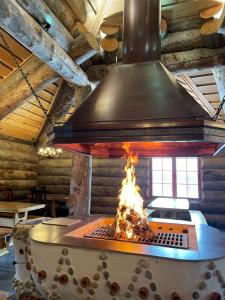 a stove with fire in a room with a ceiling at Utsjoki Arctic Resort in Utsjoki +22 photos