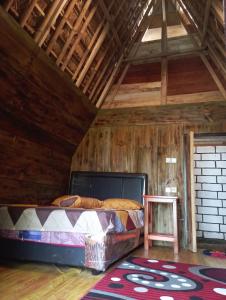 a bed in a room with a wooden ceiling at Sumilir Riverside Retreat in Banyuwangi