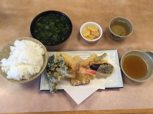 une assiette de nourriture avec du riz et des légumes et des sauces dipping dans l'établissement オーベルジュ鳴門, à Naruto