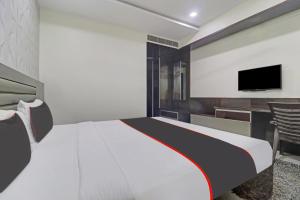 1 dormitorio con 1 cama y TV en la pared en Collection O 81197 Hotel Star Inn, en Hyderabad