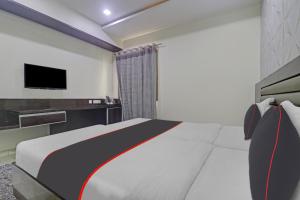 1 dormitorio con 1 cama y TV en la pared en Collection O 81197 Hotel Star Inn, en Hyderabad