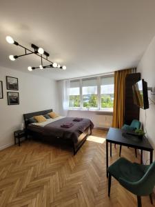 a bedroom with a bed and a table and a television at Apartament 21 in Gdynia