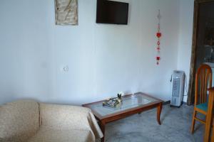 a living room with a couch and a table at Afroditi Ground floor apartment in Achílleion
