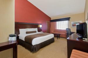 a hotel room with a bed and a couch and a television at Crowne Plaza Albuquerque by IHG in Albuquerque