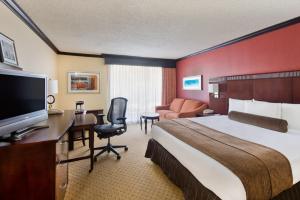 a hotel room with a bed and a desk with a television at Crowne Plaza Albuquerque by IHG in Albuquerque +64 photos