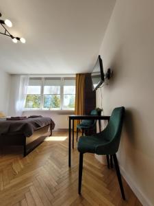 a bedroom with a bed and a table and chairs at Apartament 21 in Gdynia