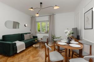 - un salon avec un canapé vert et une table dans l'établissement Stylish Apartment Nowolipie close to Warsaw Old Town Square by Renters, à Varsovie