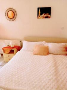 ブダペストにあるGold Apartmentの白いベッドと壁の絵が備わるベッドルーム1室が備わります。