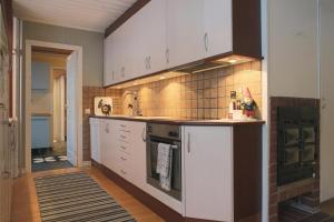 a kitchen with white cabinets and a stove top oven at Aurora Cabin in Kiruna