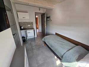ein kleines Schlafzimmer mit einem Bett und einer Küche in der Unterkunft Karpacka 8 in Bydgoszcz