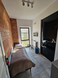 - une chambre avec un lit et un mur en briques dans l'établissement Karpacka 8, à Bydgoszcz
