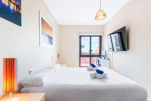 a bedroom with a large white bed with two stuffed animals on it at MEDANO4YOU Jaquita Paradise Holiday Home in El Médano