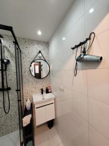 a white bathroom with a sink and a mirror at Apartament 21 in Gdynia