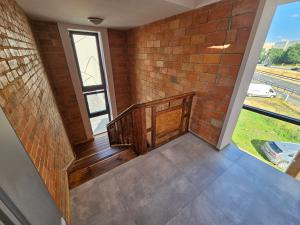 a staircase with a brick wall and a window at Karpacka 8 in Bydgoszcz